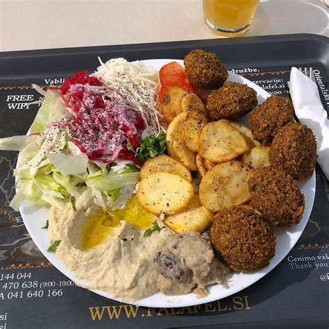 Notranjost restavracije Abi Falafel z orientalskim dekorjem in gostinci pri pultu