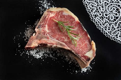 Goveji steak, počivajoč pod aluminijasto folijo na leseni deski