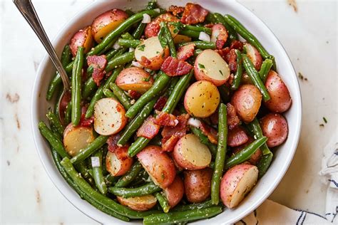 Thematic photo of green beans and potatoes on a plate with sour cream