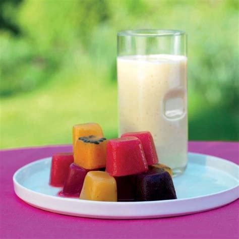 Fotografija kozarca ohlajenega češnjevega kompota z listom mete in ledenimi kockami.