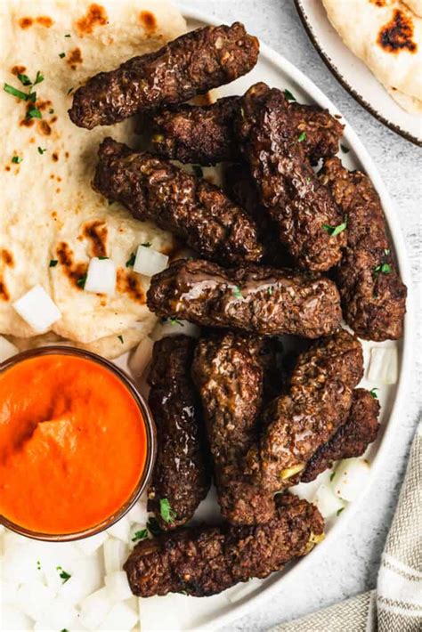 Thematic photo of cevapi on a plate with ajvar and onions