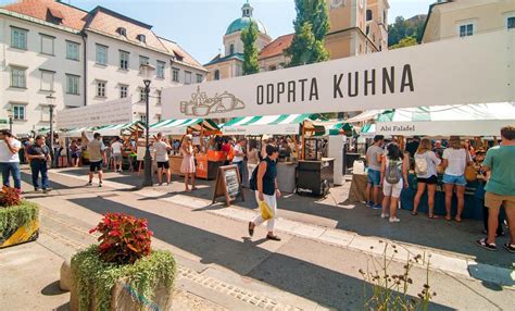 Slika živahne Odprte kuhne s pisanimi stojnicami in obiskovalci