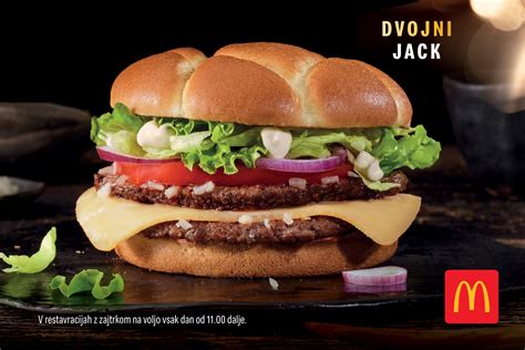 Fotografija sočnega burgerja z uležanim mesom in svežimi dodatki