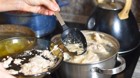 Photo of a person skimming fat from soup with a ladle