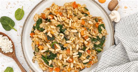 raznobarvna zelenjavna rižota na krožniku, okrašena s svežimi zelišči