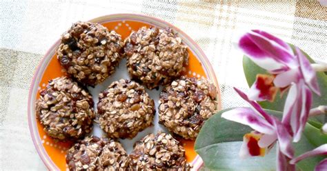 Blizu posnetek piškotov, ki razkriva teksturo ovsenih kosmičev, koščke čokolade in oreščkov.