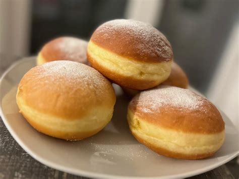 Pripravljene pustne krofe, posute s sladkorjem v prahu, pripravljene za postrežbo.