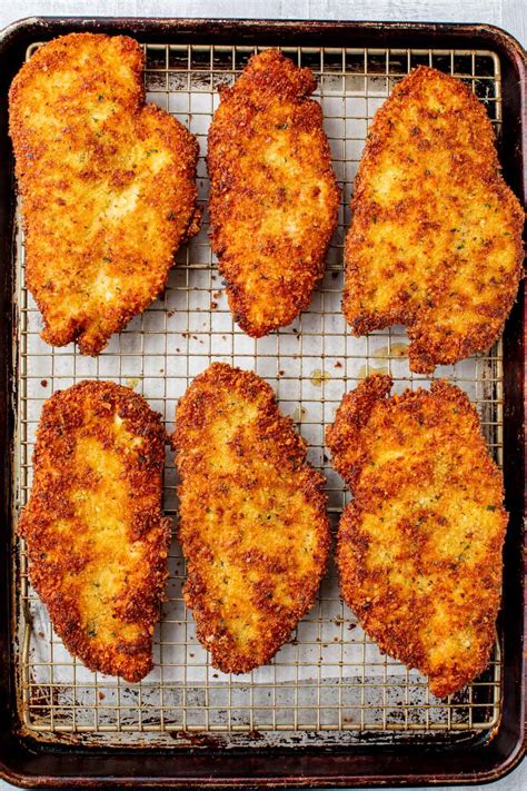 Thematic photo of crispy breaded chicken fillets on a baking sheet, fresh out of the oven