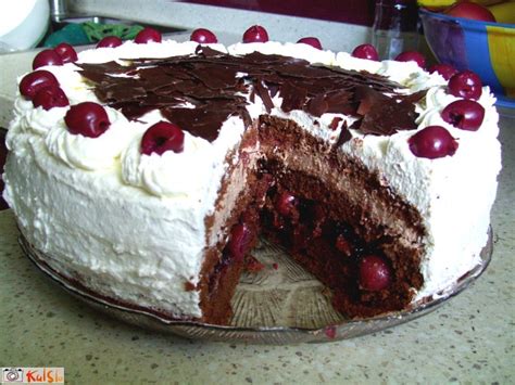 Klasična torta črni gozdiček, okrašena s svežimi višnjami in čokoladnimi ostružki