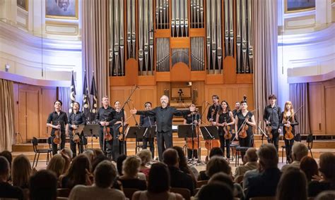 Fotografija orkestra, ki izvaja glasbo v koncertni dvorani