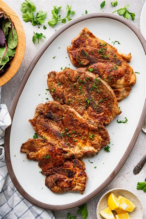 Photo of oven-baked pork steaks with melted cheese and vegetables