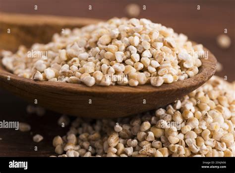 Thematic photo of barley groats in a bowl with a wooden spoon