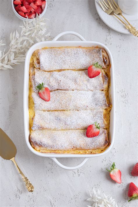Prikaz zlato zapečenih gratiniranih palačink z orehovim posipom v pekaču