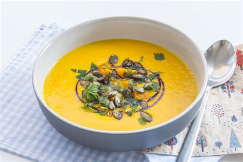 kremna bučna juha v krožniku, okrašena z bučnimi semeni