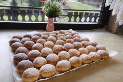 Tematska fotografija krofov z marmelado in sladkorjem v prahu
