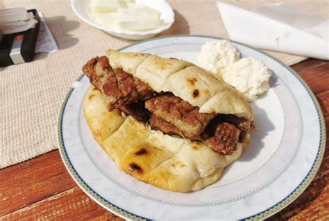 Fotografija serviranih čevapčičev z lepinjo, čebulo in ajvarjem