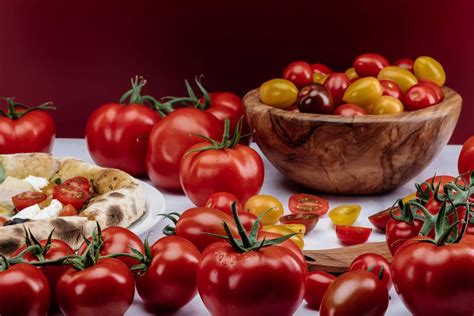 različni sveži paradižniki na lesenem pultu