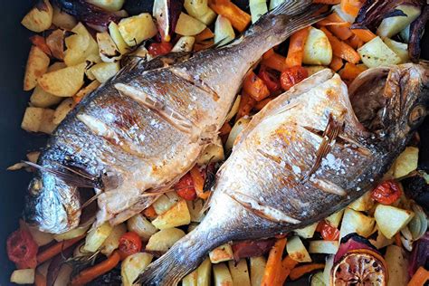 narezani paradižniki in čebula na pekaču, pripravljeni za peko v pečici