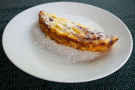Pečene skutine palačinke v pekaču, posute s sladkorjem v prahu