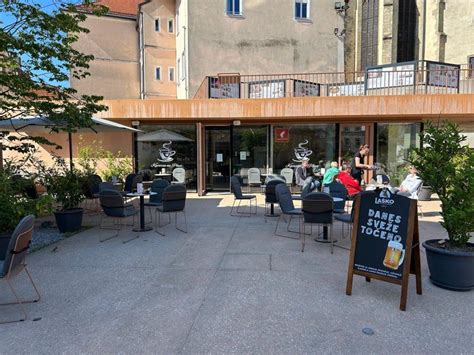 Fotografija zunanjosti kavarne Cacao z gosti na terasi v mestnem okolju