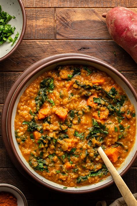 Photo of a creamy lentil and sweet potato curry in a bowl with a spoonful of yogurt