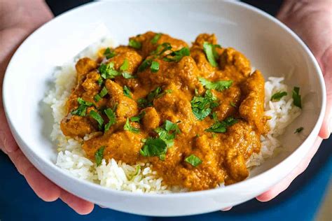 Thematic photo of a finished non-spicy chicken curry dish with basmati rice and fresh coriander
