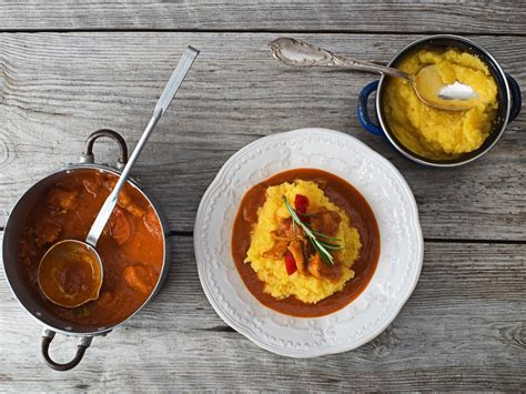 Krožnik nojevega golaža, postreženega s polento.