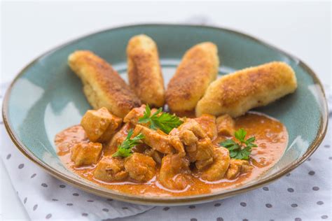 Sveže narezane sestavine za piščančji paprikaš: piščančje meso, čebula, česen, paprika, paradižnik