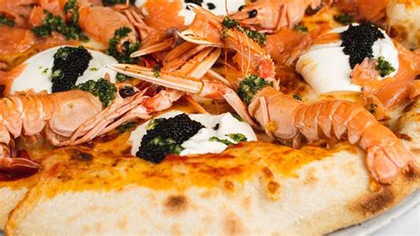 Različne jedi na jedilniku Pizzerie Barjan, vključno s picami in malicami