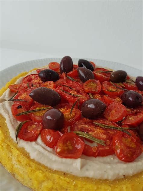 Fotografija veganske polenta pite s češnjevimi paradižniki in humusom