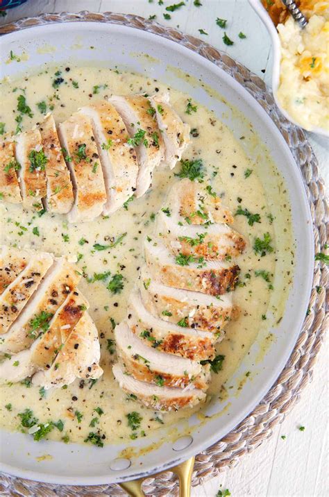 Thematic photo of a plate with chicken breast in a creamy sauce, garnished with herbs
