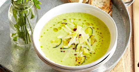 Prikaz kuhane zelenjavne juhe v loncu, z izpostavljenimi svežimi zelišči.