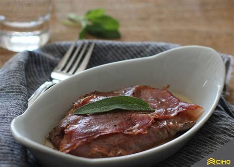 pripravljena jed Saltimbocca na krožniku, prekrita z omako