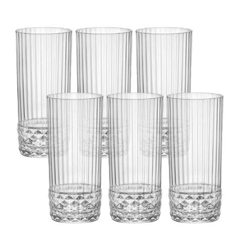 Steklen kozarec s cvetovi šentjanževke, prekritimi z olivnim oljem, postavljen na sončno okensko polico.