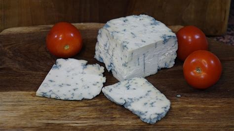 Polovica sira Roquefort z izrazitimi modrimi žilami.