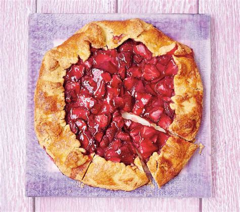 Fotografija korakov priprave jagodne pite: razvaljano testo v pekaču, naložene jagode, oblikovana mrežica iz testa