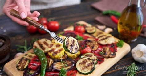 Raznolika zelenjava pripravljena za peko na žaru, vključno s paprikami, bučkami, jajčevci, gobami, koruzo in čebulo.