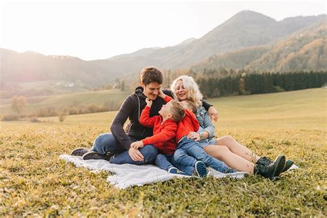 Fotografija družine, ki uživa ob pikniku z žarom.