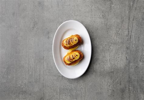 Ilustracija postopka paniranja kroketa v jajce in drobtine