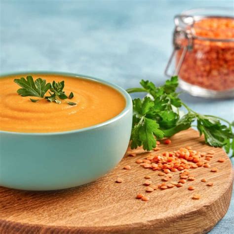 skleda paradižnikovo oranžne juhe iz leče, okrašena s peteršiljem