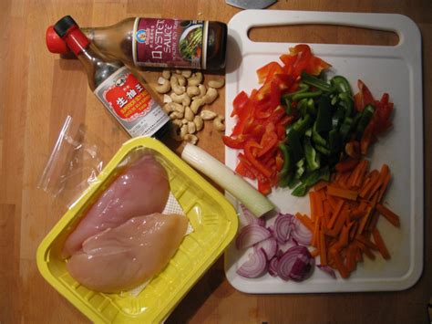 Narezan piščanec, paprika, indijski oreščki in por pripravljeni za kuhanje v voku.