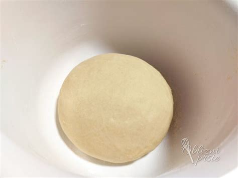 Fotografija vzhajanega krušnega testa v posodi.