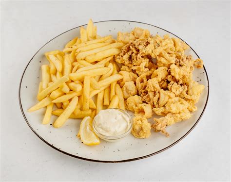 različne jedi, ki se postrežejo s tatarsko omako: ocvrti lignji, pomfrit, ribji file