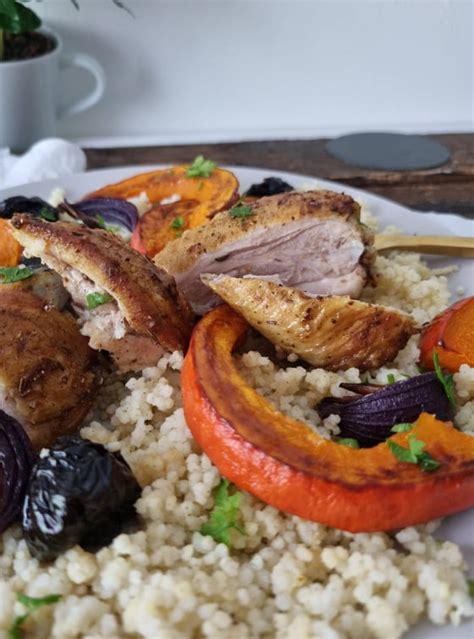 Fotografija piščanca s grozdjem in rdečo čebulo.