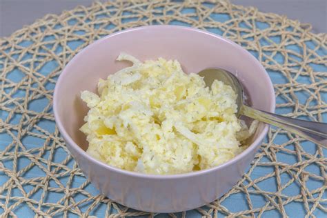 Prikaz pripravljenega krompirja, kumar in čebule v skledi, pripravljenega za mešanje s prelivom