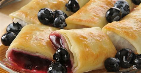 slika naloženih polnjeniih palačink z borovničevim prelivom