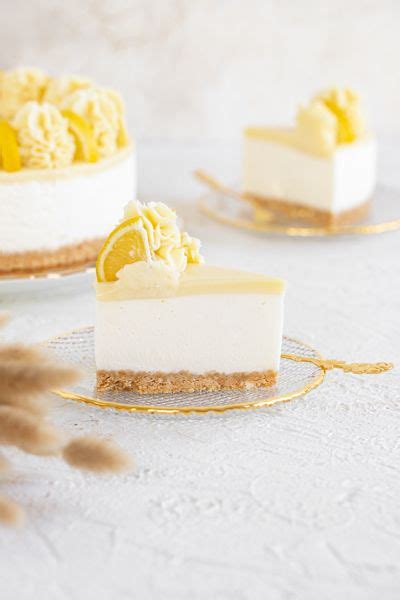 Tematska fotografija sveže limonine torte, okrašene s karameliziranimi limoninimi rezinami in bučnimi semeni.