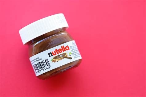 Infografika s primerjavo sestavin: kupljena Nutella (sladkor, palmovo olje) vs. domača Nutella (lešniki, datlji, kakav)