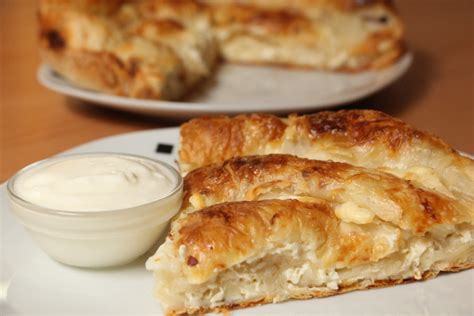 Okrogli sirov burek, postavljen v pekač, pred pečenjem