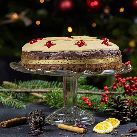 Praznično postrežen božični kolač z marcipanom in oreščki na okrašeni mizi